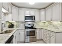 Updated kitchen with white cabinets, stainless steel appliances, and granite countertops at 795 S Alton Way # 4C, Denver, CO 80247