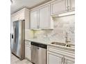 This updated kitchen features white cabinets, granite countertops, and stainless steel appliances at 795 S Alton Way # 4C, Denver, CO 80247
