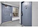 View of a condo entrance featuring unit door, utility door, window, and carpeted floor in shared space at 14214 E 1St Dr # B08, Aurora, CO 80011