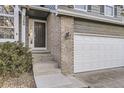 Close-up of a home featuring a brick entryway and a modern, dark-colored front door at 3268 E 136Th Pl, Thornton, CO 80602