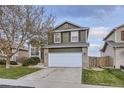Traditional two-story home featuring a white garage door and a manicured front yard at 3268 E 136Th Pl, Thornton, CO 80602