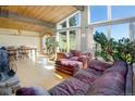 Bright living room featuring wood floors, exposed beams, and large windows with outdoor views at 100 Wildcat Ln, Boulder, CO 80304