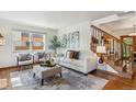Cozy living room showcasing natural light, a staircase, and hardwood floors at 1109 Jersey St, Denver, CO 80220