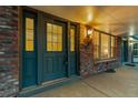 Close-up of double front door showcasing brick facade, porch, and sidelight window at 7068 E Briarwood Dr, Centennial, CO 80112