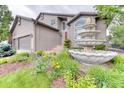 Close up of landscaped front yard featuring a tiered fountain and well manicured garden at 16458 W Ellsworth Dr, Golden, CO 80401