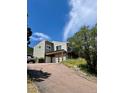 Exterior of home with carport, garage and long driveway up a hill at 6943 Fox Cir, Larkspur, CO 80118