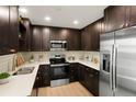 Modern kitchen with stainless steel appliances, dark cabinets, and white countertops at 14544 March Dr, Denver, CO 80239
