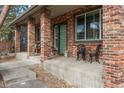 Inviting front porch with brick columns, seating, and a stylish entrance door, creating a warm welcome at 4495 Rainbow Ln, Broomfield, CO 80020