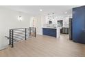 Bright kitchen featuring stainless appliances, white cabinets, and a contrasting blue breakfast bar at 1238 Rosemary St, Denver, CO 80220