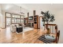 Spacious living room with hardwood floors, a brick fireplace, and large windows for lots of natural light at 1408 W Briarwood Ave, Littleton, CO 80120