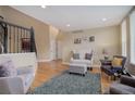 Bright living room with hardwood floors, plush seating, and stairway access at 10914 W Coco Pl, Littleton, CO 80127