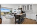 Open living space with a balcony, hardwood floors, stainless steel appliances, and an antique kitchen island at 700 N Washington St # 1104, Denver, CO 80203