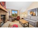 Cozy living room with a stone fireplace, comfortable seating, and a large window with scenic mountain views at 50 Mountain Thunder Dr # 1402, Breckenridge, CO 80424