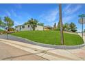 Landscaped corner lot with lush lawn, concrete border, and mature trees under a sunny blue sky at 4640 W Ellsworth Ave, Denver, CO 80219