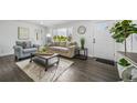 Bright living room featuring hardwood floors, a neutral sofa, and an abundance of natural light at 4640 W Ellsworth Ave, Denver, CO 80219