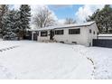 Charming ranch home with updated exterior, snowy landscape, and a black fence at 12029 W Dakota Dr, Lakewood, CO 80228