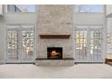 Living room with a stone fireplace and large windows with a view of the outdoors at 7 Mockingbird Ln, Cherry Hills Village, CO 80113