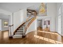 Grand foyer featuring a curved staircase, hardwood floors, and a stunning chandelier at 7 Mockingbird Ln, Cherry Hills Village, CO 80113