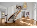 Grand foyer with a curved staircase, hardwood floors, and a striking chandelier at 7 Mockingbird Ln, Cherry Hills Village, CO 80113