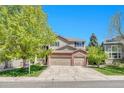 Inviting two-story home featuring a brick facade, three-car garage, and a well-manicured front yard at 10062 Eagle Valley Way, Highlands Ranch, CO 80129