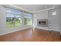 Bright living room with hardwood floors, a modern fireplace, and large windows overlooking the neighborhood at 3116 Jonquil St, Castle Rock, CO 80109