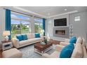 Bright living room with fireplace, hardwood floors, large windows and modern furnishings at 3116 Jonquil St, Castle Rock, CO 80109
