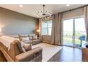 Bright living room with hardwood floors, modern chandelier, and sliding glass doors to the balcony at 3375 New Haven Cir, Castle Rock, CO 80109