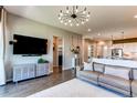 Stylish living room featuring a TV, modern decor, and an open layout leading to the kitchen at 3375 New Haven Cir, Castle Rock, CO 80109