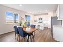 Inviting dining area with ample natural light and stylish furnishings adjacent to the modern kitchen at 5805 Red Barn Ave, Mead, CO 80504