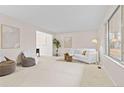 Bright and airy living room featuring neutral decor, large windows, and comfortable seating at 6602 S Vance St, Littleton, CO 80123