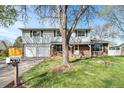 Two-story home with light siding, brick accents, and a spacious two-car garage on a well-manicured lawn at 6323 W 85Th Ave, Arvada, CO 80003