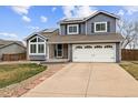 Charming two-story home with a well-manicured lawn and a spacious two-car garage, complemented by solar panels at 9392 Crestmore Way, Highlands Ranch, CO 80126