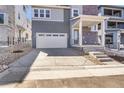 Exterior view of a gray home with a two-car garage and drought-tolerant landscaping at 11902 Octave Ave, Parker, CO 80134