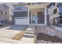 Well-manicured lawn and xeriscaping accent this modern home's covered entrance at 11902 Octave Ave, Parker, CO 80134