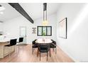 Bright dining area with modern lighting, seating for six, and view into an open kitchen featuring skylights at 19185 Shadowood Dr, Monument, CO 80132