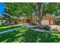 Brick home with a well-manicured lawn and mature trees highlighting the curb appeal at 8136 S Glencoe Ct, Centennial, CO 80122