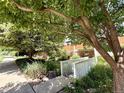 Inviting front yard with mature trees, vibrant landscaping, and a quaint white bridge at 1111 Maxwell Ave # 228, Boulder, CO 80304