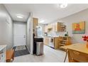 Open kitchen with stainless appliances, light wood cabinets, and adjacent dining area with door to entry at 1111 Maxwell Ave # 228, Boulder, CO 80304