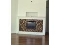 A decorative fireplace with a white mantel and light and dark brown mosaic tile surround at 11761 E Canal Dr, Aurora, CO 80011