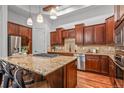 Open kitchen with granite countertops, custom cabinets, stainless steel appliances, and a center island at 7821 Inverness Blvd, Englewood, CO 80112