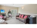 Relaxing living room featuring a comfortable brown leather sofa and an elegant hanging chair at 725 High St, Erie, CO 80516