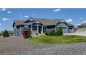 Attractive blue home boasts a well-manicured lawn and gravel landscaping at 31353 E 163Rd Ave, Hudson, CO 80642