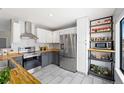 Well-lit kitchen featuring stainless steel appliances, wood countertops, white subway tile, and ample storage shelves at 8755 W Cornell Ave # 14-5, Lakewood, CO 80227