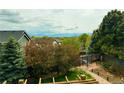 Serene backyard view with mature trees, landscaping, and mountain views at 9687 Timbervale Ct, Highlands Ranch, CO 80129