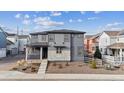 Modern two-story home featuring a stylish mix of gray siding and stone accents in a cozy community at 8403 Rush Creek Ave, Littleton, CO 80125