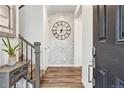 Elegant foyer showcasing wood floors, staircase, stylish decor, and a decorative accent wall, creating a welcoming entrance at 8403 Rush Creek Ave, Littleton, CO 80125