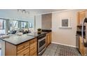 Kitchen with tile backsplash, stainless steel appliances, and view into living room at 1050 N Corona St # 304, Denver, CO 80218