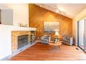 Cozy living room featuring a brick fireplace, wood floors, and ample natural light at 9400 E Iliff Ave # 411, Denver, CO 80231