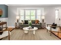Cozy living room featuring stylish furniture, a bay window with shutters, and warm natural light at 9502 W Hialeah Pl, Littleton, CO 80123
