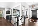 Bright foyer with staircase, dark wood floors, statement lighting, and open floorplan at 12927 Woodridge Dr, Longmont, CO 80504